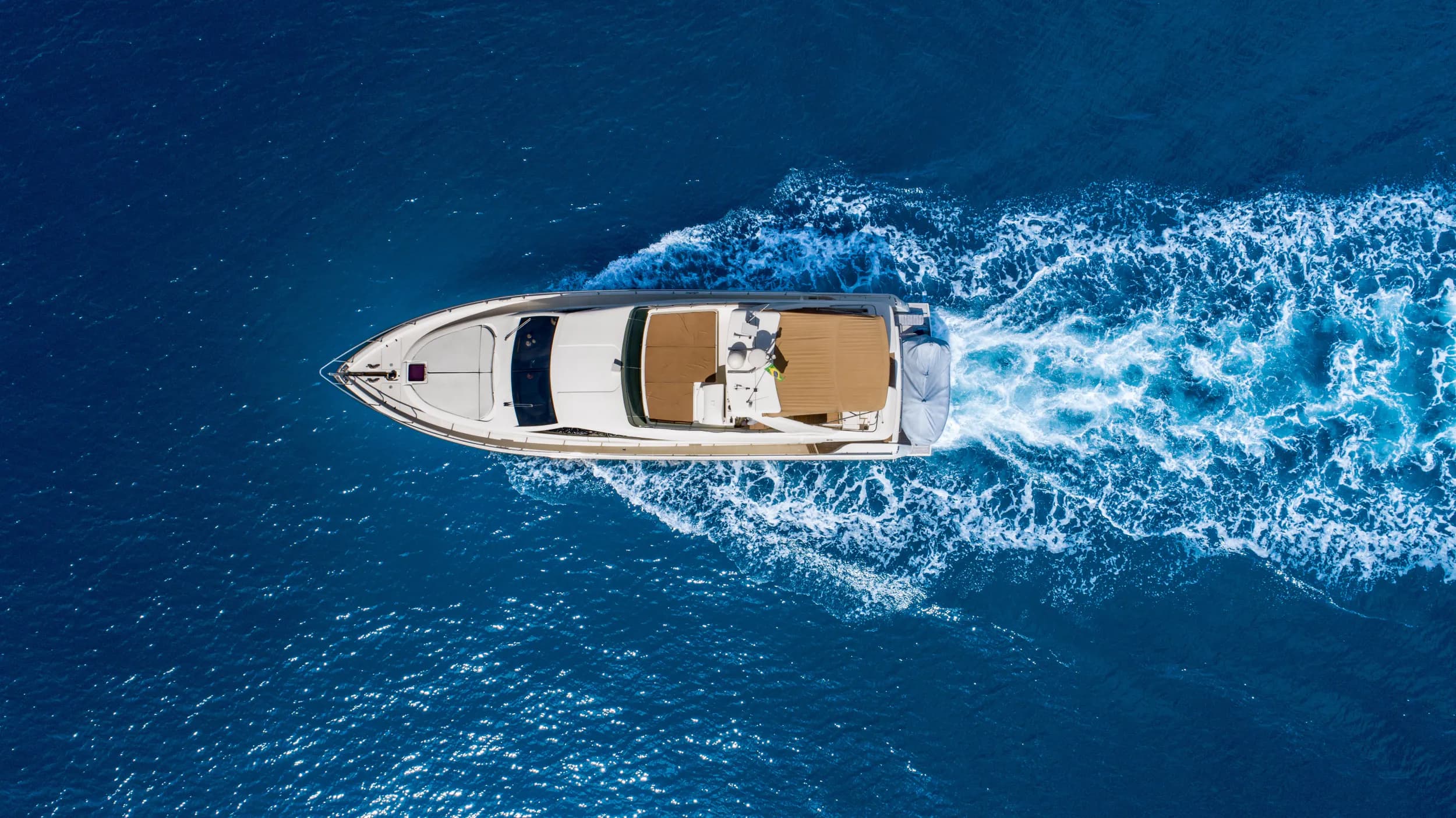 Aerial view of a motor yacht running through deep blue water
